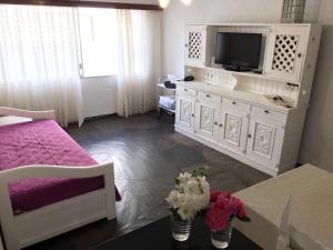 una sala de estar con TV en un armario blanco en Punta del Este frente al mar, 2 ambientes en Playa Mansa Parada 9, Edificio Paracas, en Punta del Este