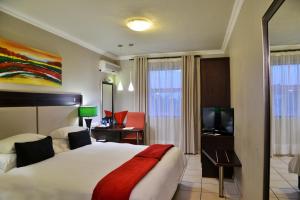 a hotel room with a bed and a television at BON Hotel Empangeni in Empangeni