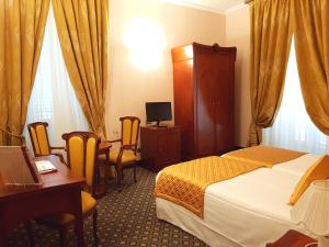 a hotel room with a bed and a desk and chairs at Hotel Berchielli in Florence