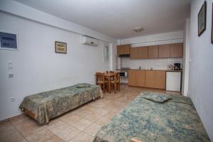 a room with two beds and a kitchen at Ilian Beach & Apartments in Rethymno Town