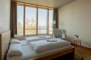 a bedroom with two beds and a large window at SUKHAVATI Apartments in Bad Saarow