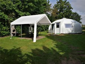 a white tent in a yard with a table at Iglo Bungalow 22 in Chaam