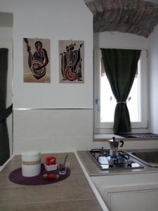 a kitchen with a stove and pictures on the wall at B&B Il Buon Cammino in Roccamandolfi