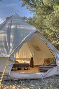 a canvas tent with a bed and a couch in it at Shauri Glamping in Noto