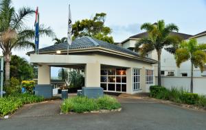 a building with palm trees in front of it at BON Hotel Empangeni in Empangeni