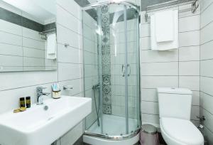 a bathroom with a shower and a sink and a toilet at Castell Hotel in Kissamos