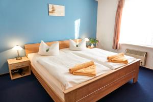 a bedroom with a large bed with two towels on it at Haus Strandeck in Zingst