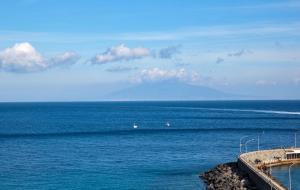 a large body of water with a mountain in the background at Relais Maresca Luxury Small Hotel & Terrace Restaurant in Capri