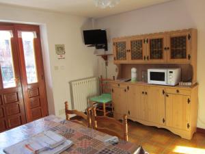 une cuisine avec une table et un four micro-ondes sur une armoire dans l'établissement Apartment Tea, à Gressoney-Saint-Jean