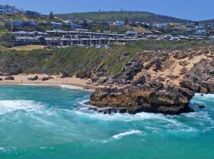 an aerial view of a beach with rocks and houses at Brenton Haven Beachfront Resort in Knysna +70 photos