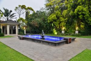 a swimming pool with a fountain in a yard at BON Hotel Empangeni in Empangeni