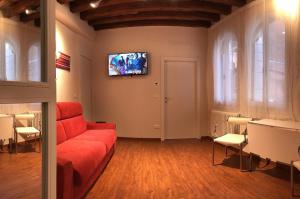 een woonkamer met een rode bank en een flatscreen-tv bij Ca' Terlotta in Venetië