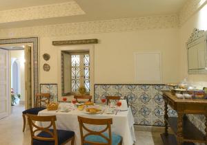 a dining room with a white table and chairs at Dar ALOUINI in Kairouan