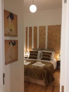 Schlafzimmer mit einem Bett mit Gemälden an der Wand in der Unterkunft Sapateiros Street 207 - City Center Apartment in Lissabon