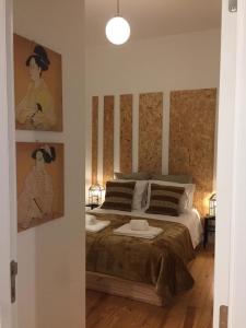 a bedroom with a bed with paintings on the wall at Sapateiros Street 207 - City Center Apartment in Lisbon