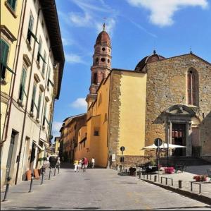 een stadsstraat met een gebouw met een klokkentoren bij SWEET TUSCANY CAVOUR in Arezzo