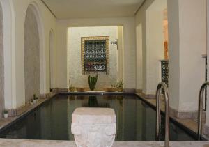 a swimming pool with a fountain in a building at Dar ALOUINI in Kairouan