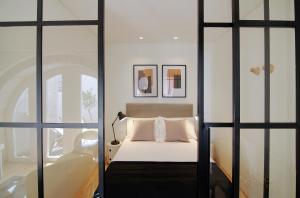 a bedroom with a bed and two glass doors at HM - The Garden in Porto