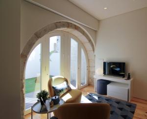 een boog in een woonkamer met een bank en een tv bij HM - The Garden in Porto
