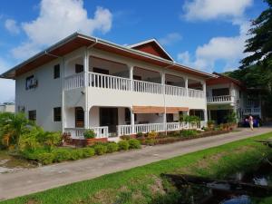 un bâtiment blanc avec un toit rouge dans l'établissement Tourterelle Holiday Home, à Grand Anse