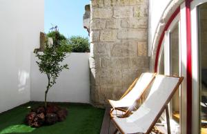 twee stoelen en een boom op een balkon bij HM - The Garden in Porto