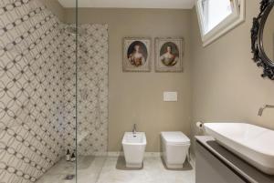 La salle de bains est pourvue d'un lavabo, de toilettes et d'une douche. dans l'établissement Dimora Tito Speri near Arena, à Vérone