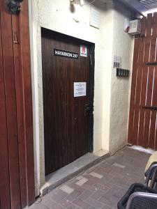 a wooden door in a building with a sign on it at Dotan's Boutique Guesthouse - By The Beach! in Tel Aviv