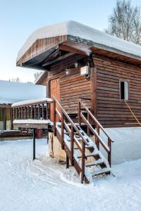 um chalé de madeira com uma escada na neve em Diligence с мангальной зоной Выборг на смирновском шоссе em Vyborg