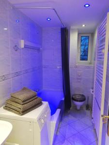 a purple bathroom with a toilet and a shower at Apartment mea in Berlin +31 photos