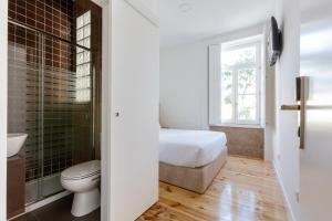 a bathroom with a bed and a toilet and a window at São Francisco in Matosinhos +65 photos