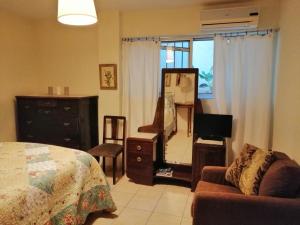 a bedroom with a bed and a dresser and a mirror at St. Thomas Bed and Breakfast in Paianía