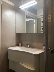 een badkamer met een wastafel en een spiegel bij Appartement sur la digue in Knokke-Heist