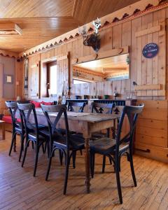 un comedor con una gran mesa de madera y sillas en La Principauté de Comborciere, en La Toussuire