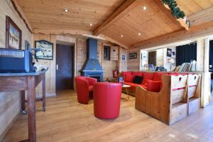 a living room with red chairs and a stove at La Principauté de Comborciere in La Toussuire