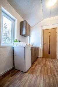 uma cozinha com um frigorífico branco e uma janela em Diligence с мангальной зоной Выборг на смирновском шоссе em Vyborg