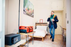 un homme traversant une chambre avec un lit dans l'établissement The Beehive, à Rome