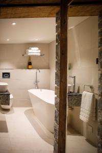 a bathroom with a tub and a toilet and a sink at Gileston Manor-Self catering in Saint Athans