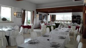 a dining room with white tables and white chairs at Tenuta Di Pietra Porzia in Frascati