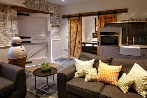 a living room with a couch and a kitchen at Gileston Manor-Self catering in Saint Athans