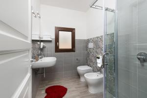 Un baño con inodoro, lavabo y ducha. en KORY Bed & Breakfast, en San Vito lo Capo