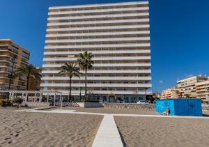 a large white building on the beach with palm trees at Stellamar - Paseo Maritimo in Fuengirola