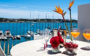 - une table avec des verres à vin et une vue sur le port de plaisance dans l'établissement Es Varadero, à Portocolom