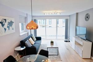 a living room with a blue couch and a glass table at 2BR/2Bath Luxury Modern Flat in the City London in London