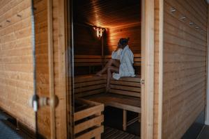 Eine Frau, die in einer Sauna sitzt. in der Unterkunft Hotel Monínec - Depandance Nová Javorka in Moninec
