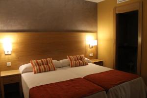 a bedroom with a large bed with two pillows at Hotel Carmen in La Cala de Mijas