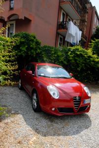 ein rotes Auto, das vor einem Gebäude parkt in der Unterkunft Villa Caribe affittacamere in Monterosso al Mare