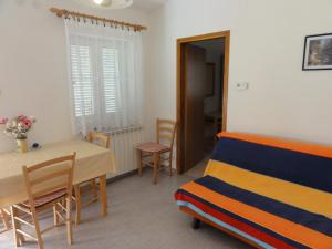 Cette chambre comprend un lit, une table et des chaises. dans l'établissement Apartment Bolko - near the beach, à Banjole