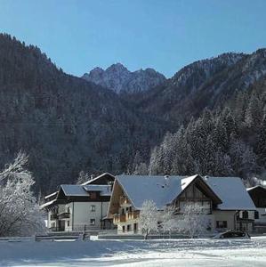 una casa nella neve di fronte a una montagna di B&B al Buondì a Camporosso in Valcanale