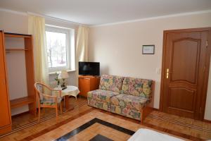 ein Wohnzimmer mit einem Sofa und einem TV in der Unterkunft Pension Francesco in Nürnberg