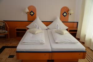 ein Bett mit weißen Kissen darüber in der Unterkunft Pension Francesco in Nürnberg